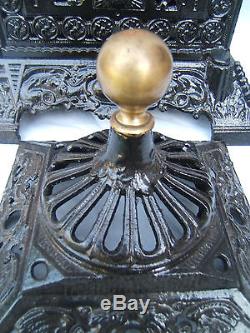 Antique Cathedral stove with brass rising oil lamp. Cast iron oil lamp